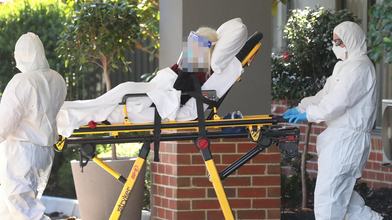 A woman is transferred into a patient transport van and taken away from Arcare Maidstone Aged Care Centre. Picture: David Crosling