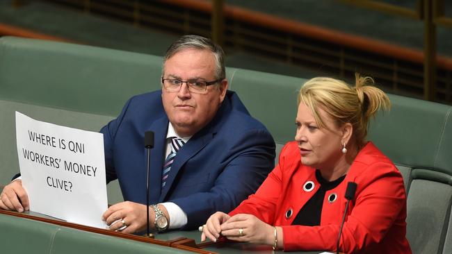 Backbencher Ewan Jones holds up a prop as PUP Leader Clive Palmer addresses the House of Representatives today.
