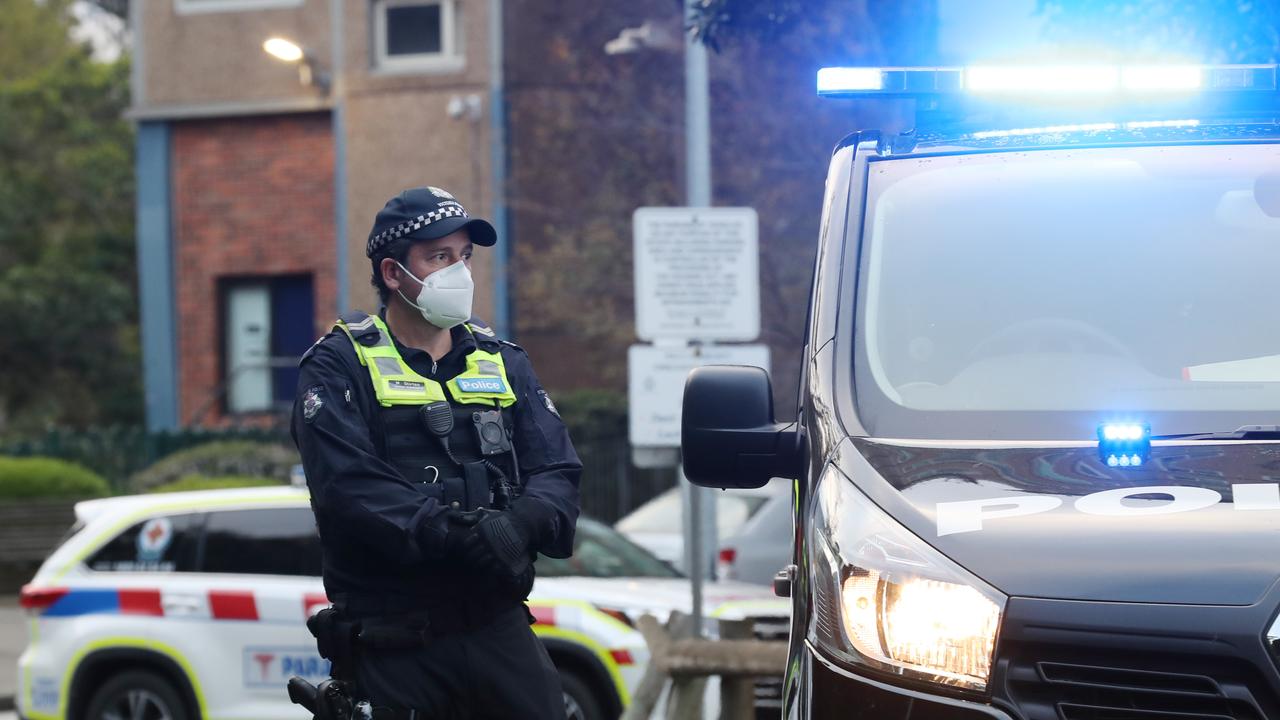 Police on the scene at government housing towers on Racecourse Rd in Flemington on Sunday morning. Picture: David Crosling