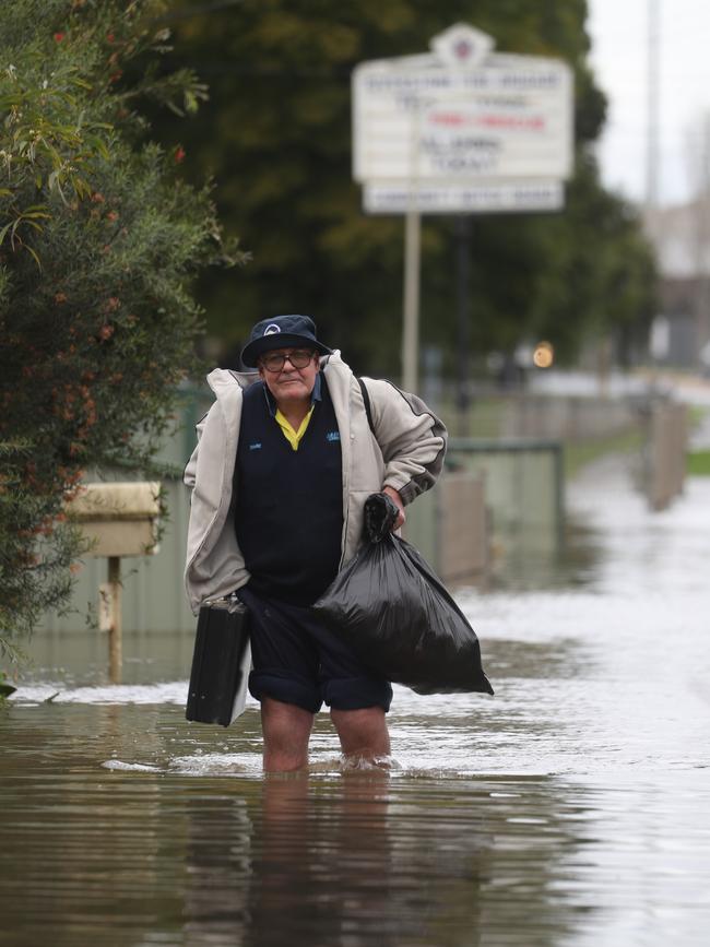 Bruce McCaull leaves his Riverstone Pde property with belongings after water entered his home. Picture: John Grainger