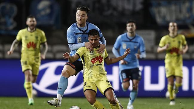 Ulises Davila playing for Phoenix is tacked by Sydney FC’s Alexander Baumjohann.