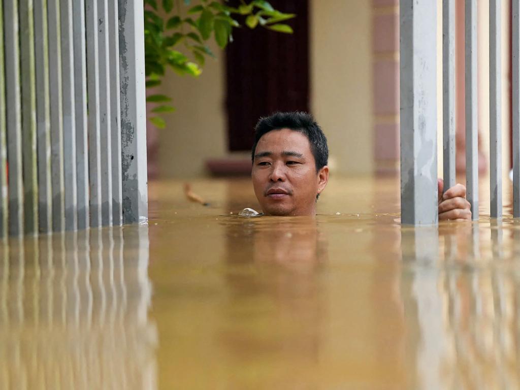 A man wades through flood waters outside his house in Thai Nguyen province. Picture: Huu Hao / AFP