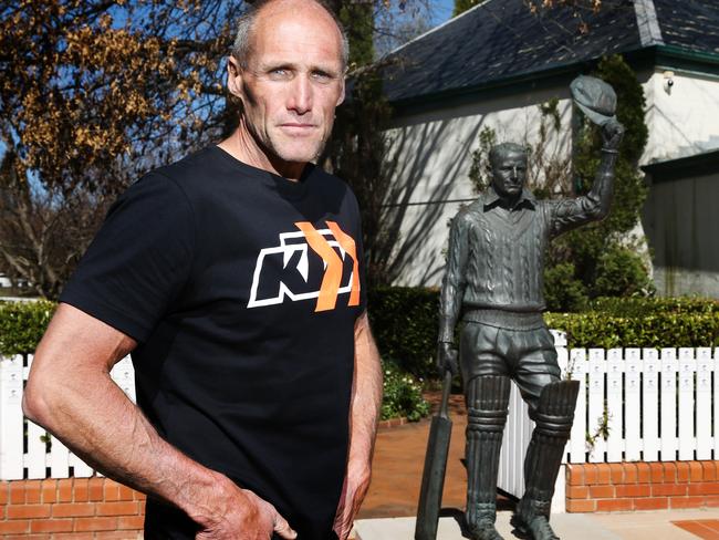 Tony Lockett with a statue of Sir Donald Bradman. Picture: Michael Klein