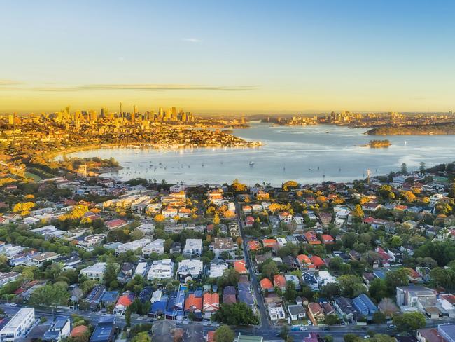 Wealthy Eastern suburbs of Sydney city around Harbour in aerial view with soft morning light and blue sky. Australian housing generic