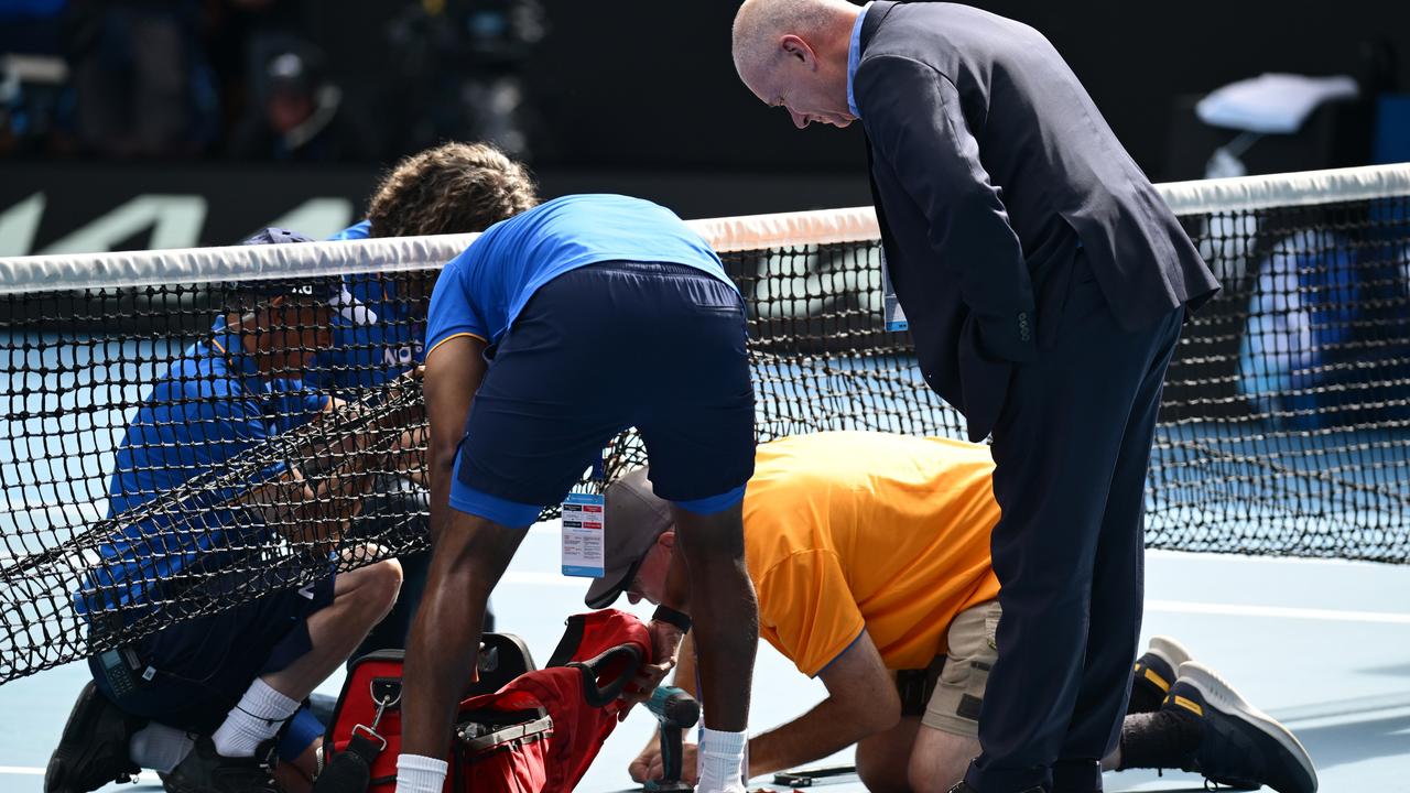 Officials scramble to address the broken net which caused a 20-minute delay in play. Pioture: Hannah Peters / Getty Images