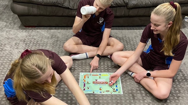 John Paul College students play exercise Monopoly.