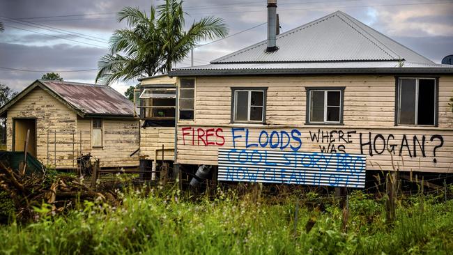 This photo taken on May 15, 2022, shows houses with political graffitis after the recent floods devastation in the New South Wales town of Lismore. - Two months since an unprecedented flood, thousands of residents remain homeless and are struggling to recover. (Photo by Patrick HAMILTON / AFP) / TO GO WITH: Australia-vote-climate-flood, FOCUS by Maddison Connaughton