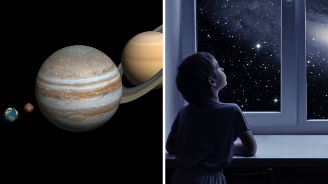 A little boy is standing near the window and looking outside, imagining boundless space with myriad of stars