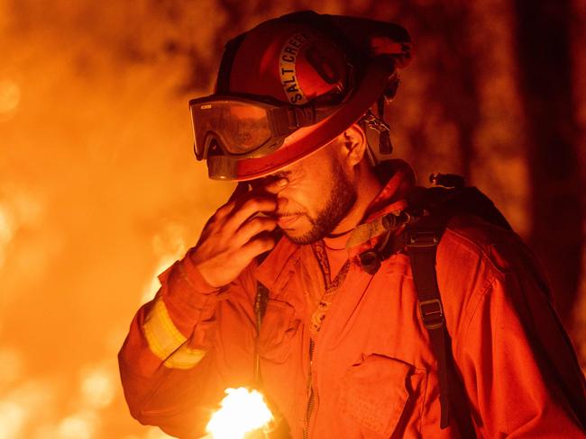 An inmate firefighter pauses during a firing operation as the Carr fire continues to burn in Redding, California on July 27, 2018. Picture: AFP