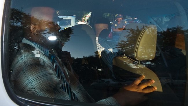 Olympian Oscar Pistorius, with his head covered, leaves the Brooklyn Police Station in a police vehicle for his bail hearing.