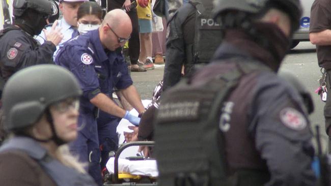 Paramedics assess the man after he was arrested by NSW Police. Picture: TNV