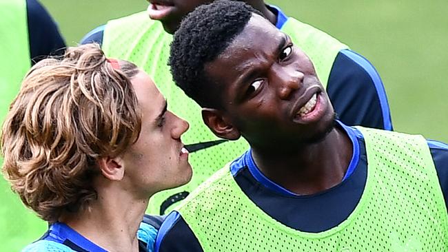 France's forward Antoine Griezmann (C) jokes with France's midfielder Paul Pogba (R)