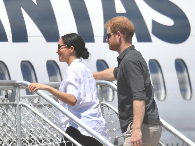 Britain's Prince Harry said they fly commercial where possible. Pictured, the Duke of Sussex and his wife Meghan boarding a plane in Australia. Picture: AAP/Darren England