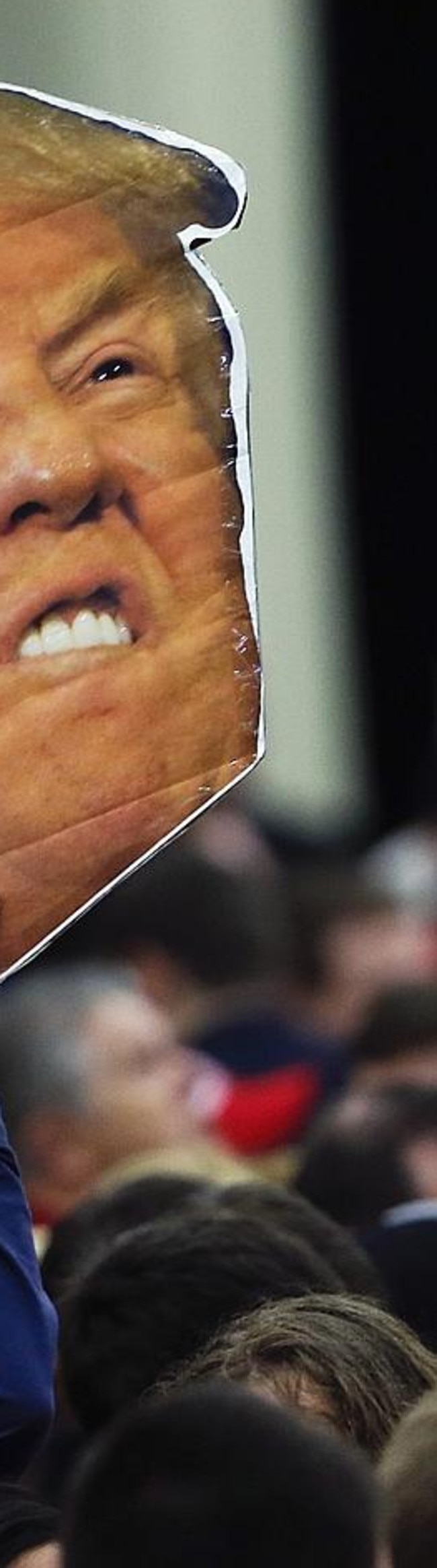 A man holds a photo of Republican presidential candidate Donald Trump before a rally on Super Tuesday.