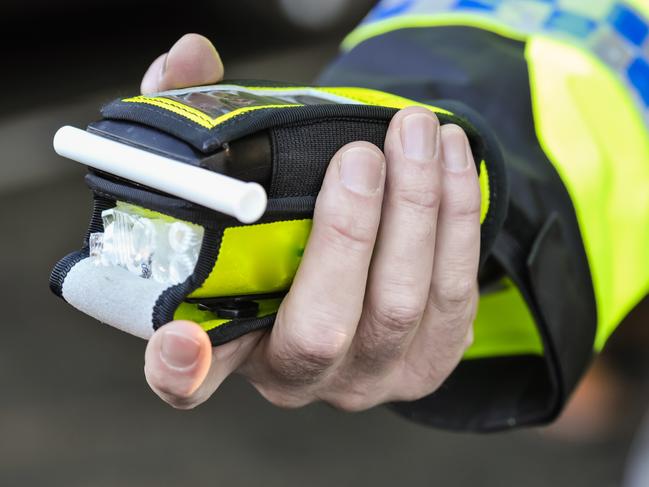 Belfast, Northern Ireland. 24 Nov 2016 - A police officer holds a roadside breathalyser alcohol breath test after taking a sample from a driver.