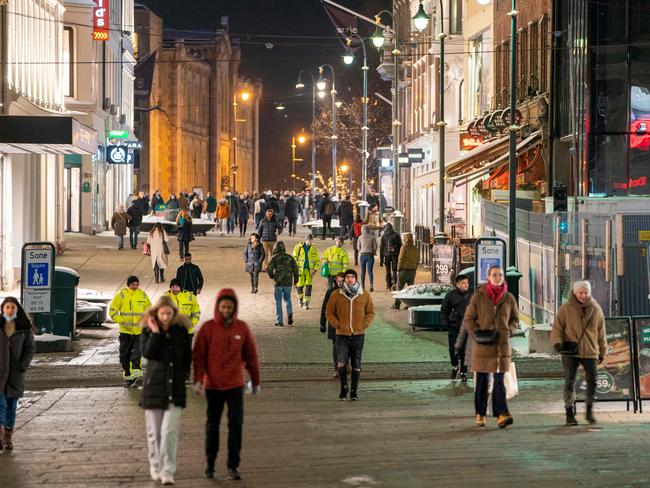 People walk along a pedestrian zone in Oslo on February 2, 2022 as the gastronomy reopens for guests. - Norway on February 1 announced it would scrap most of its Covid restrictions despite an Omicron-fuelled surge in infections, saying society must "live with" the virus. (Photo by Terje Pedersen / NTB / AFP) / Norway OUT