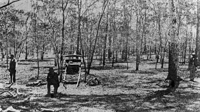 A tracker kneels as he examines the crime scene. 