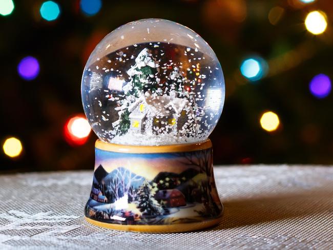 Christmas Snow Globe in front of Christmas tree lights closeup, blurred background