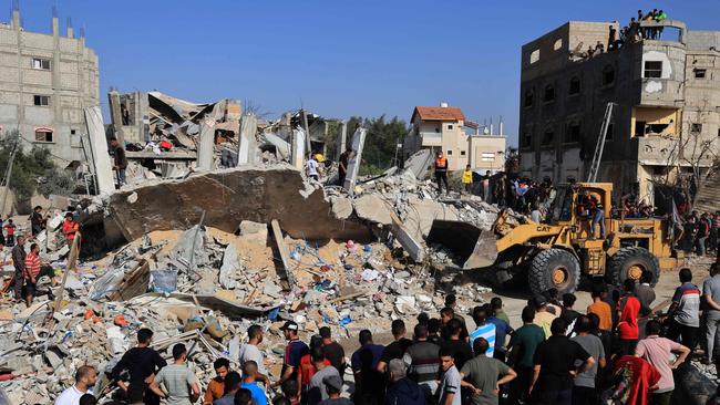 Palestinians rescuers look for survivors as others watch a digger remove concrete blocks after an Israeli strike on Rafah, in the southern Gaza Strip. Picture: SAID KHATIB / AFP