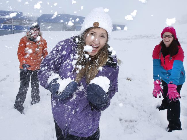 Fresh snow fall blankets Mount Buller Alpine Village during a cold snap. Snow lovers Morgan O'Brien, Ruby Walton and Alicia Lindsay, make the most of the snowfall with a traditional, two-against-one, snowball fight.    Picture: David Caird