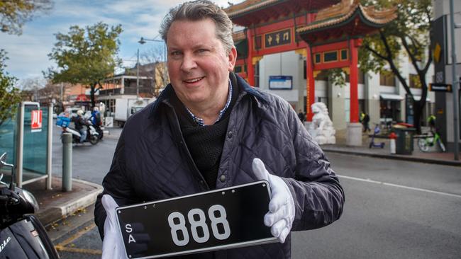 Auctioneer Stewart Kay with a prized set of 888 plates in China Town, which were sold to a private buyer in 2022. Picture: Matt Turner