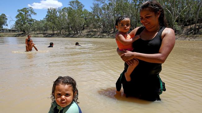 Brooke Edwards from Enngonia, about an hour north of Bourke, cooling down in the Darling River with kids Jonah (L) and Alinta. Picture: Toby Zerna