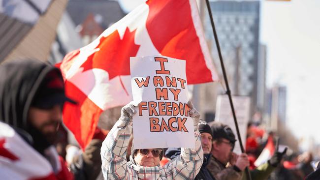 A demonstrator holds a sign during a protest against mandates related to Covid-19 vaccines and restrictions in downtown Toronto. Picture: AFP.