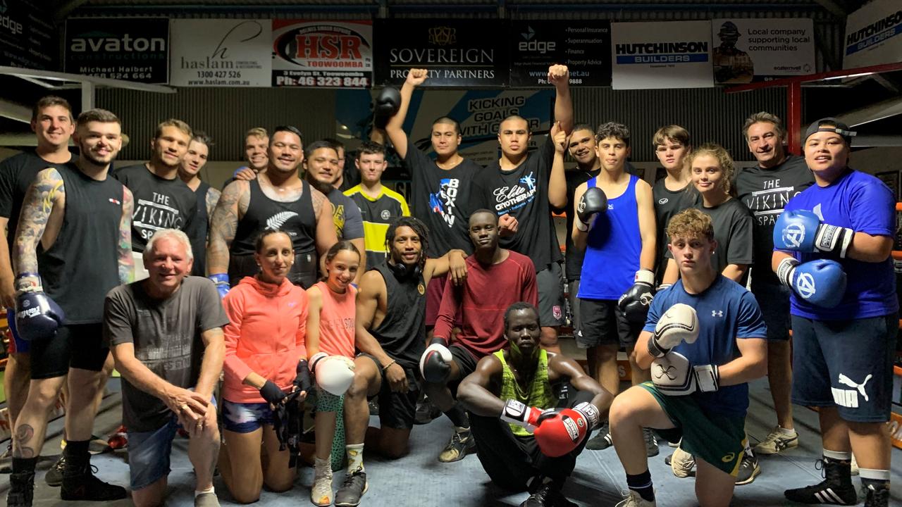 Toowoomba's Va'a brothers De La Salle (left) and Xavier raise their arms as they celebrate their Australian title wins with TGW &amp; Smithy's Gym team members and trainers in 2019.