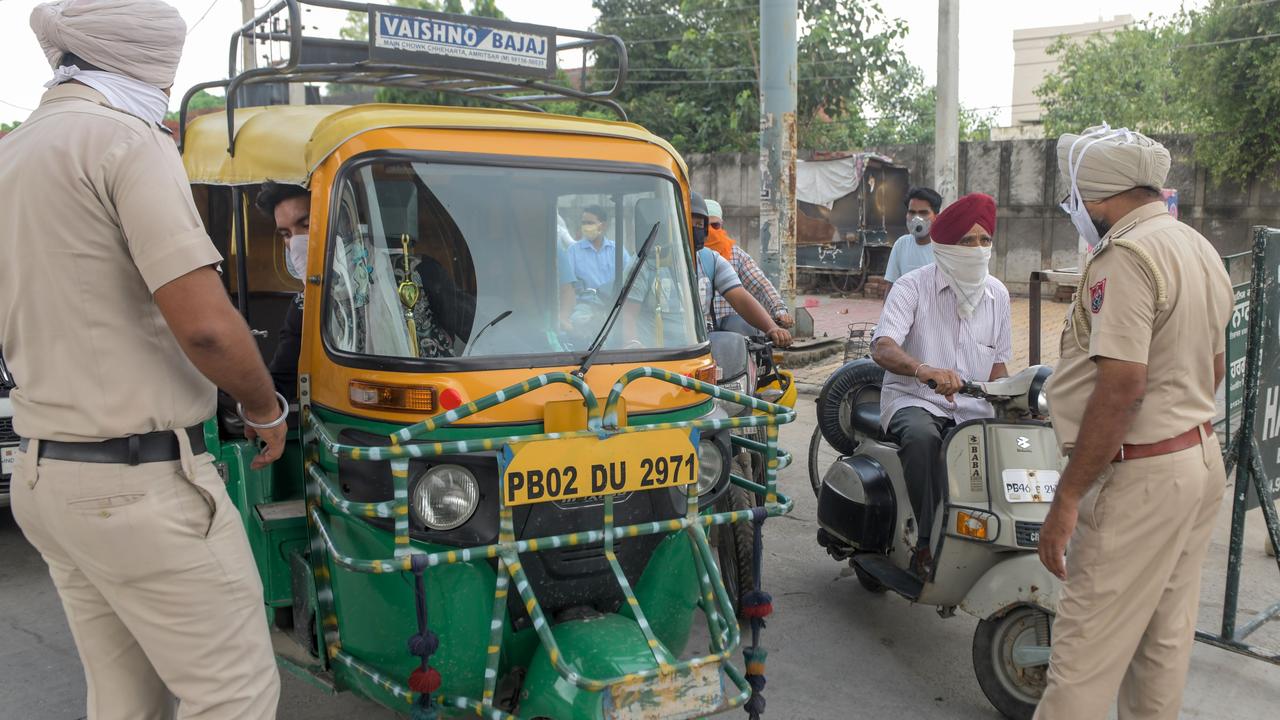 Police personnel check travel passes from commuters after lockdown norms for weekends and public holidays in the state have been imposed as a preventive measure against the COVID-19 coronavirus, in Amritsar on August 29, 2020. Picture: NARINDER NANU / AFP