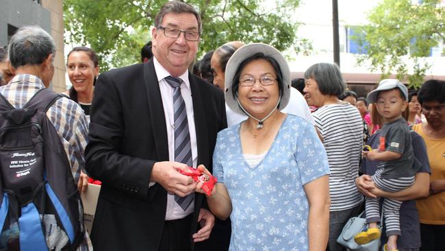 Canterbury-Bankstown Council administrator Richard Colley hands out a lucky envelope during Campsie Lunar New Year celebrations.