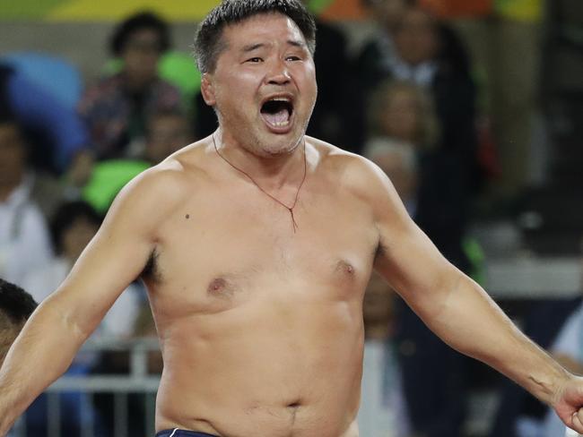 Coaches of Mongolia's wrestler Mandakhnaran Ganzorig take off their clothes in protest against the decision of the jury to award the bronze medal to Uzbekistan's Ikhtiyor Navruzov during the men's 65-kg freestyle wrestling competition at the 2016 Summer Olympics in Rio de Janeiro, Brazil, Sunday, Aug. 21, 2016. (AP Photo/Markus Schreiber)