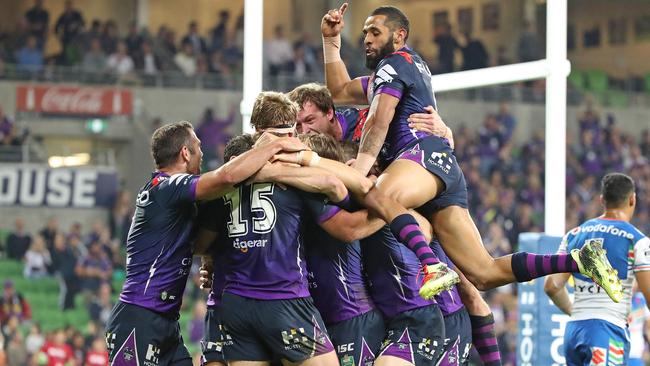 Christian Welch of the Melbourne Storm is congratulated by Josh Addo-Carr and Cameron Smith.