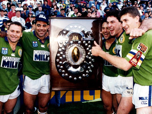 Players (L-R) Steve Walters, Ricky Stuart, Captain Mal Meninga, Laurie Daley, Bradley Clyde and Brett Mullins gathered around the JJ Giltinan Shield after Canberra defeated Canterbury in the 1994 Winfield Cup Grand Final at SFS in Sydney.