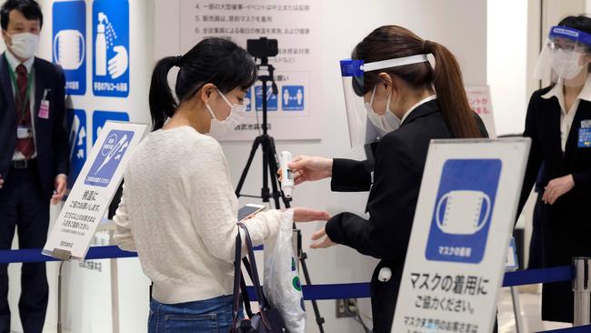 A customer receives a body-temperature check for COVID-19 infection on entering Tokyo's Seibu Ikebukuro department store, which has resumed business for the first time in 46 days since Japan’s emergency declaration. Picture: AFP