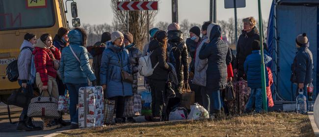 People evacuated from Donetsk walk toward the Russian emergency ministry camp in the village of Veselo-Voznesenka on the Azov Sea coast on Satutrady. Picture: AFP