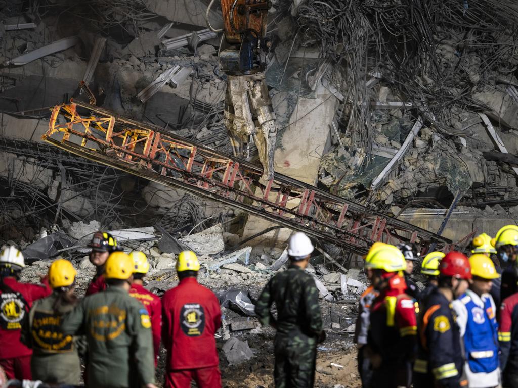 A wreckage of a crane is seen being removed by heavy machinery during a search and rescue operation. Picture: Sirachai Arunrugstichai/Getty Images