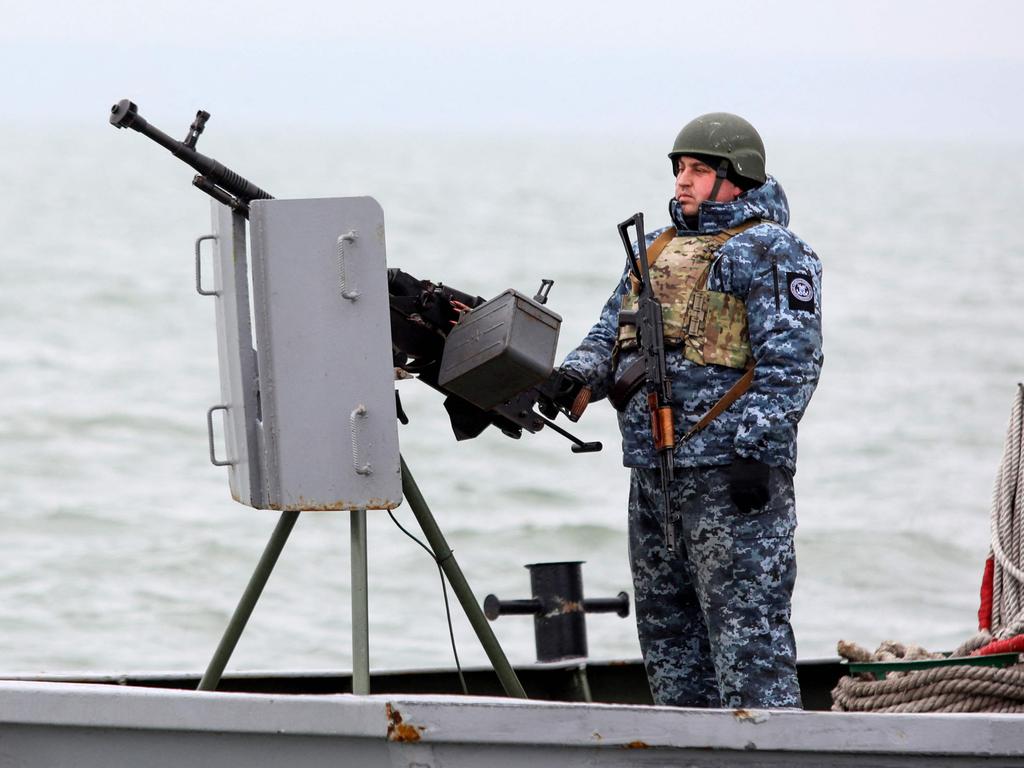 A serviceman stays in guard as he boat patrols water area of Ukraine's Black Sea port of Mariupol. Picture: AFP