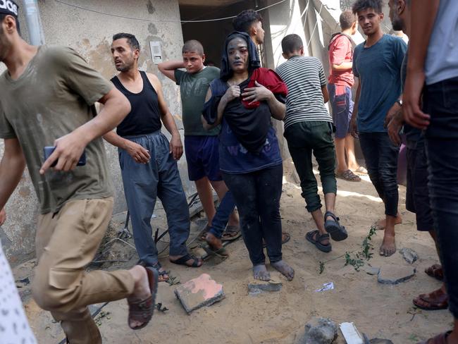 A Palestinian woman covered in dirt and dust stands next to a destroyed home following an Israeli air strike in Rafah, in the southern Gaza Strip. Picture: AFP