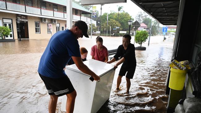 Locals help move a freezer from a Laidley restaurant. Picture: Dan Peled/Getty Images