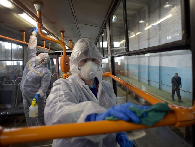 TOPSHOT - Employees wearing protective gear disinfect a tram - as part of preventive measures against the COVID-19 coronavirus - in Saint Petersburg on March 19, 2020. (Photo by OLGA MALTSEVA / AFP)