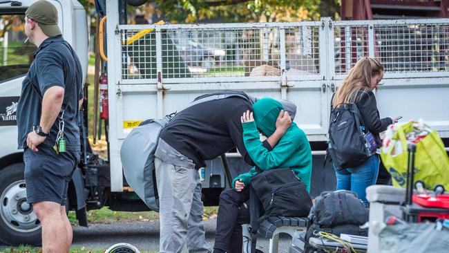 A couple embraces after being evicted. Picture: Jake Nowakowski