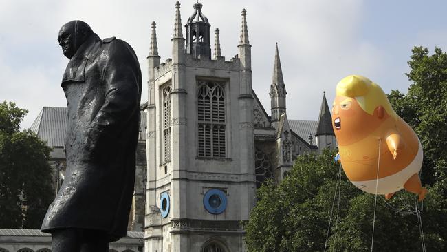 A six-metre high cartoon baby blimp of US President Donald Trump hovers next to the statue of former British Prime Minister Winston Churchill.