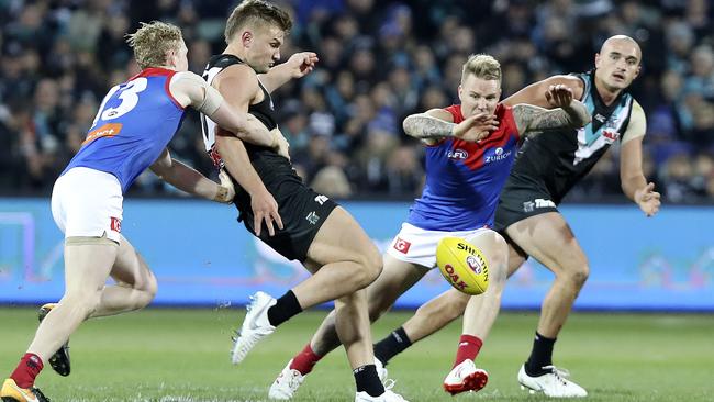 Ollie Wines gets his kick away under pressure from Melbourne’s Clayton Oliver and James Harmes. Picture SARAH REED