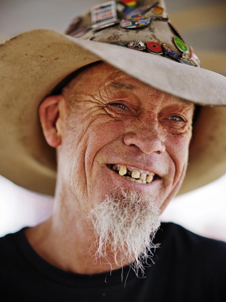 Darren Glynn in his Akubra hat showing his collection of racing pins.