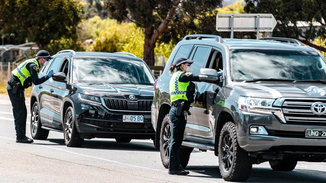 Tasmania Police officers check cars at the Tunbridge lockdown checkpoint. Picture: Josh Agnew