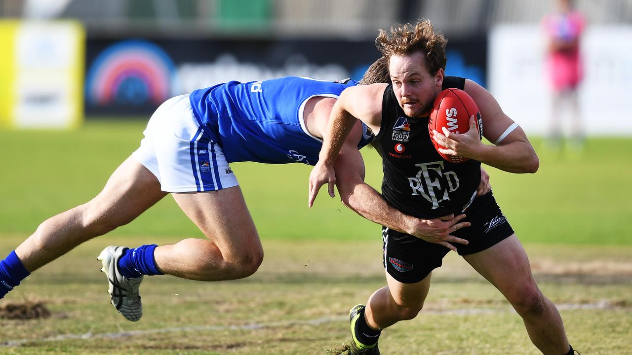 James Batty of Port Districts avoids a table from H. Hayward during the match between Port Districts and St Peter's Old Collegians at Port Districts oval at Largs Bay Saturday May 18,2019.(Image AAP/Mark Brake)