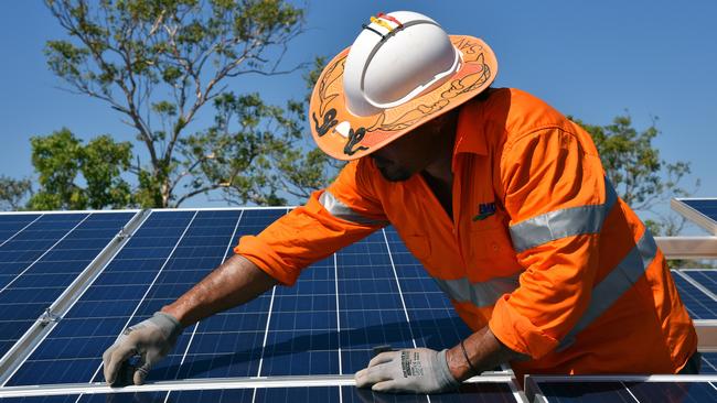 Northern Territory workers install solar panels in Daly River, Friday, August 11, 2017. Renewable energy has come to the Northern Territory bush, with solar power and battery storage set to provide an entire Aboriginal community?s daytime electricity needs for the first time. Around 500 residents from Daly River, more than 200km south of Darwin, will receive power entirely from the sun during the day when the solar and battery storage project is completed in September. (AAP Image/Lucy Hughes Jones) NO ARCHIVING