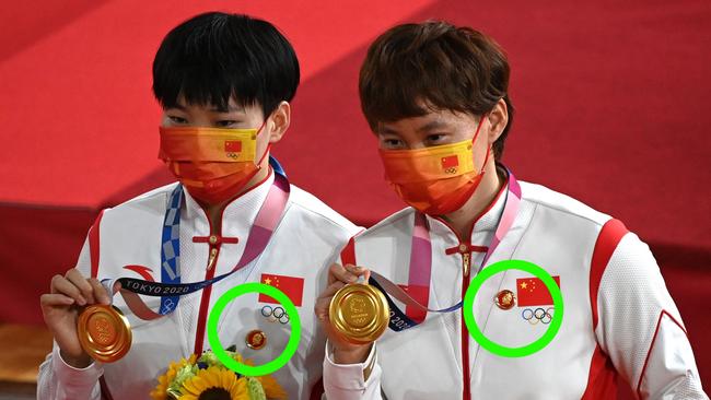 Gold medallists China's Bao Shanju (L) and China's Zhong Tianshi pose with their medals on the podium after the women's track cycling team sprint finals during the Tokyo 2020 Olympic Games at Izu Velodrome in Izu, Japan, on August 2, 2021. (Photo by Greg Baker / AFP)