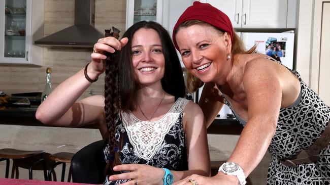 Allison Deagle holds her lopped locks, and is joined by her mother Jenny Sibley. Picture: Ross Schultz