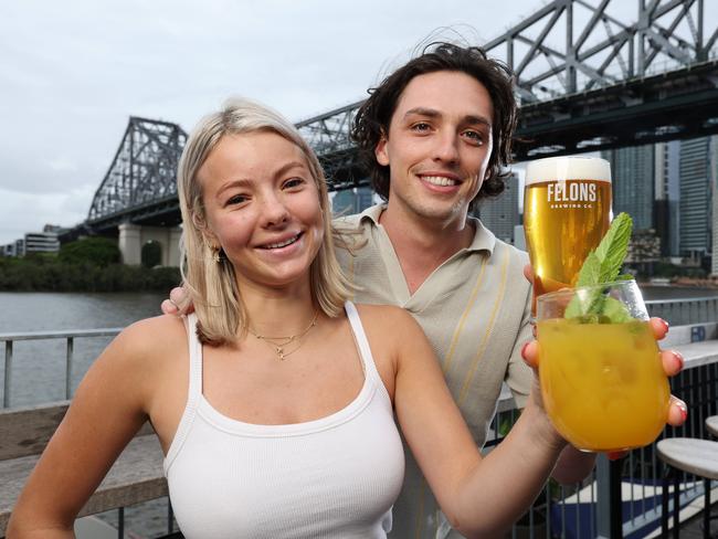 Kira Eagles and Lucas Eckersley share a drink under the Story Bridge at Howard Smith Wharves. Picture: Liam Kidston